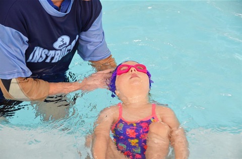 A small child being taught to swim.
