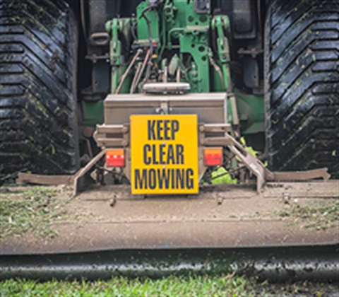 A slasher with a mowing sign on the back.