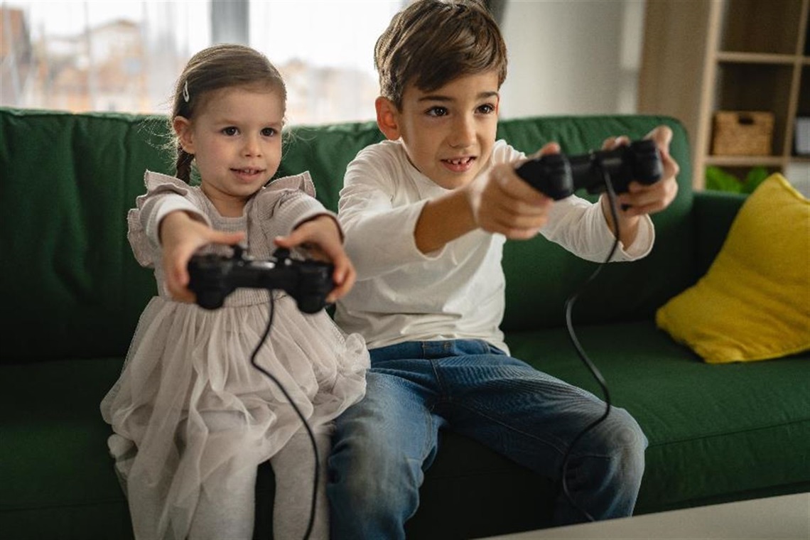A young girl and boy play video games.