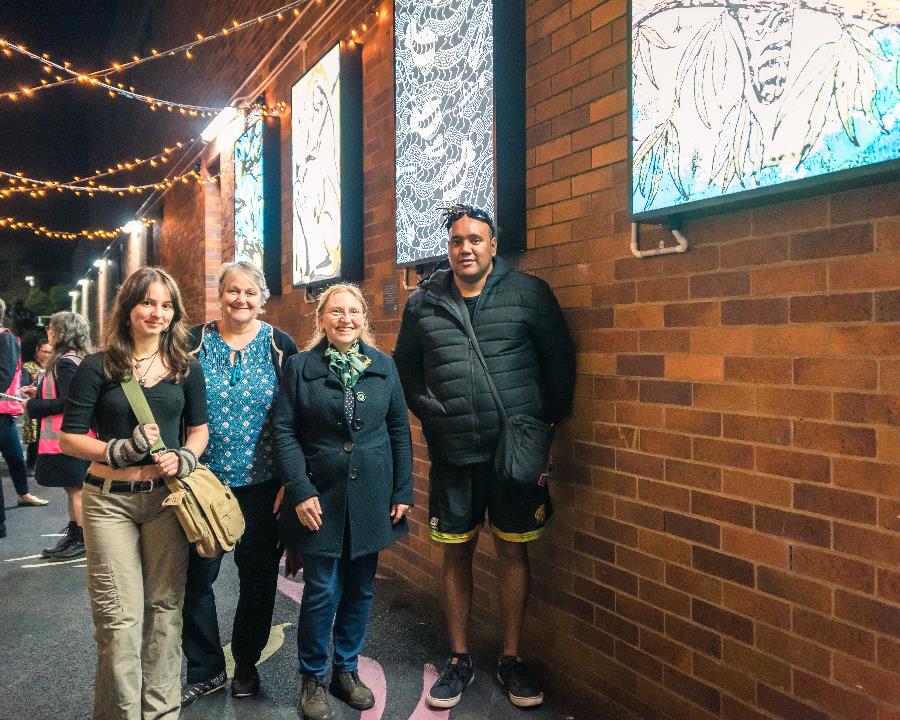 The artists in front of their light boxes.