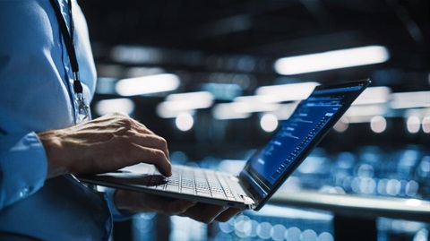 man typing into a laptop