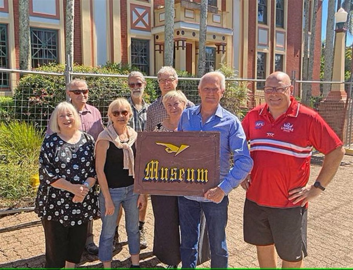 Society president Robert Smith (holding the museum sign), with Mayor Steve Krieg and museum volunteers.