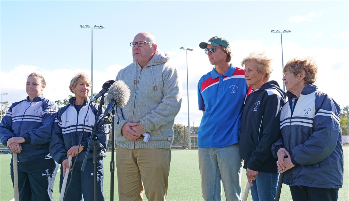 Mayor Steve Krieg and Far North Coast Hockey President Nathan Kesteven flanked by local competitors in the NSW Women's Masters Hockey Championships. 