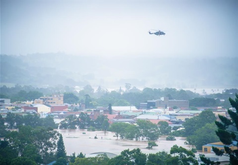 An army helicopter flies over flooded Lismore.